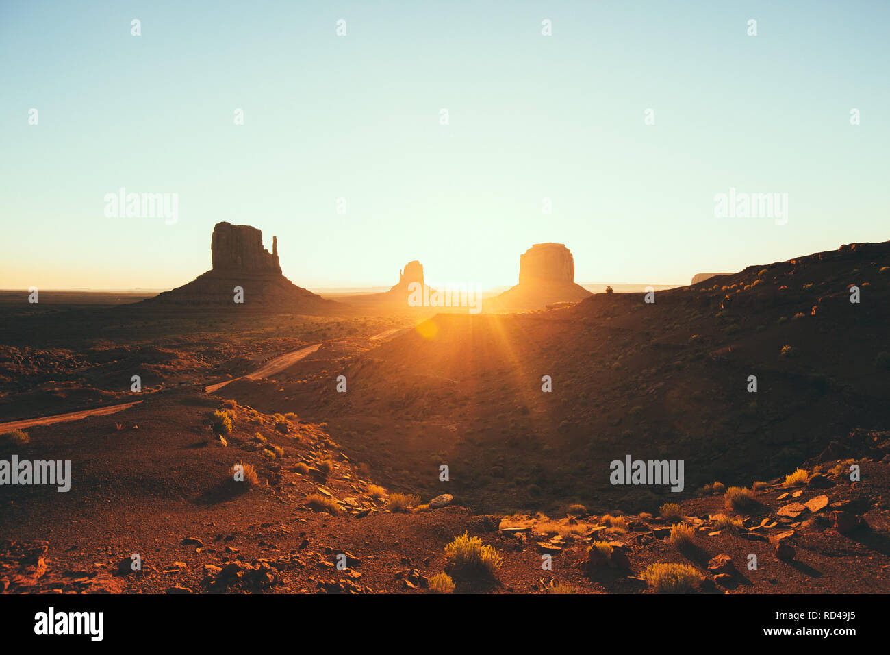 Classic view of scenic Monument Valley with the famous Mittens and Merrick Butte in beautiful golden morning light at sunrise in summer, Utah, USA Stock Photo