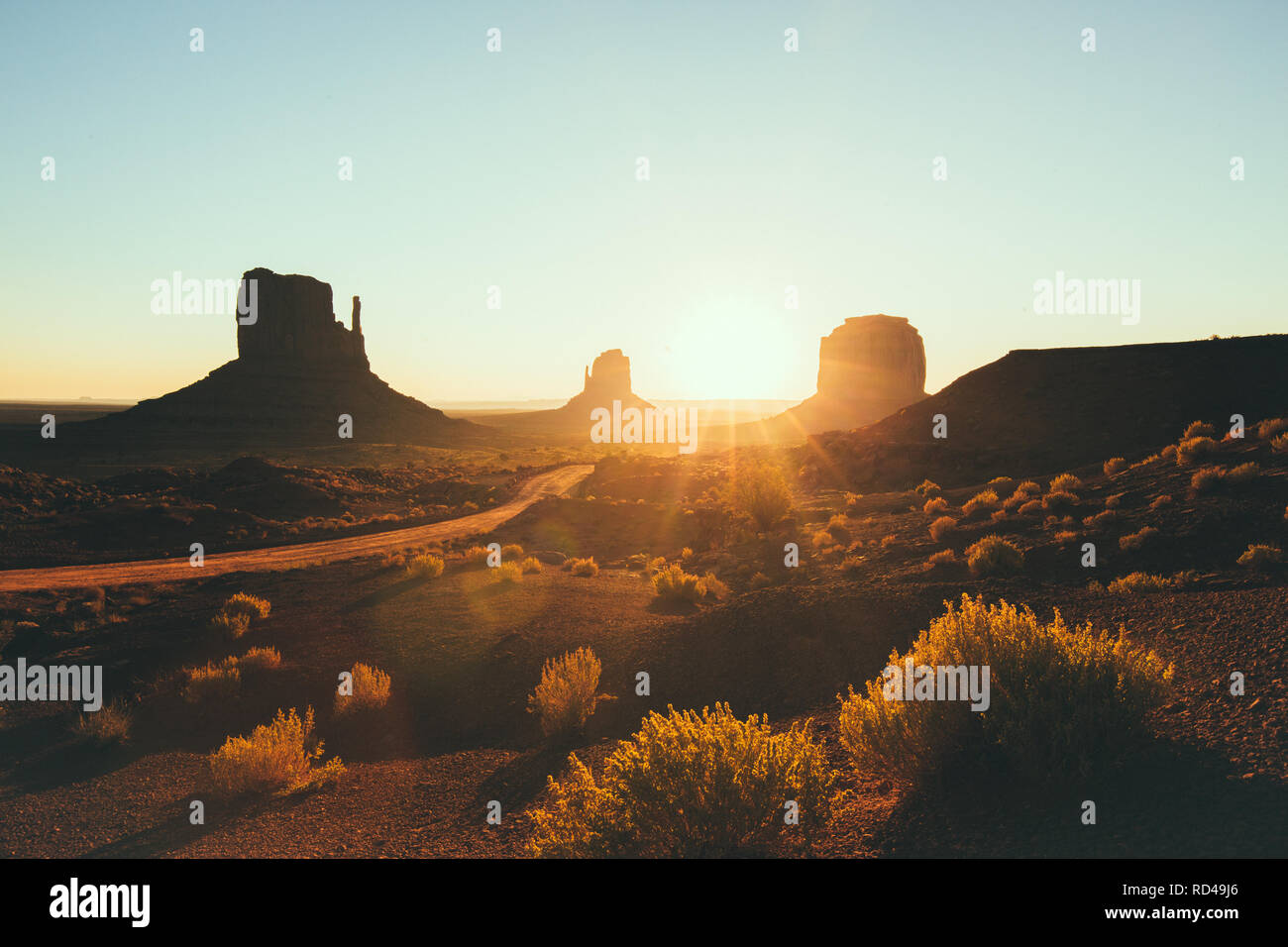 Classic view of scenic Monument Valley with the famous Mittens and Merrick Butte in beautiful golden morning light at sunrise in summer, Utah, USA Stock Photo