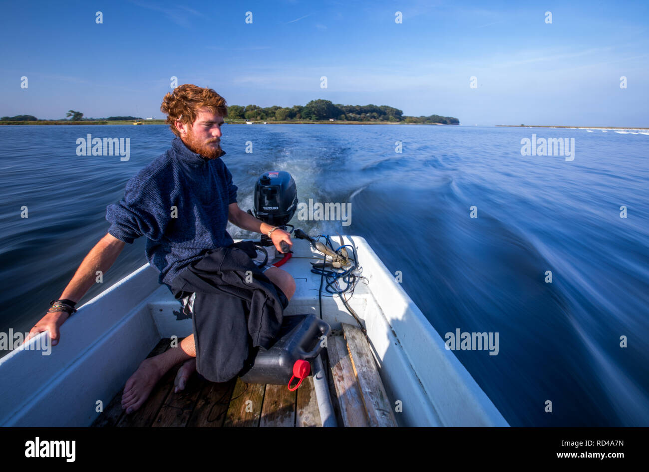 05 September 2018, Mecklenburg-Western Pomerania, Malchow (poel): Samuel Mühlichen, a federal volunteer, takes a small boat to the bird sanctuary island Langenwerder. Ornithologists count and ring thousands of migratory birds every autumn on the 21-hectare island off the Baltic island of Poel. The island in Wismar Bay, which has been a nature reserve since 1937, is Mecklenburg's oldest seabird sanctuary. From spring to mid-November, the barren island is inhabited by volunteers. Photo: Jens Büttner/dpa-Zentralbild/ZB Stock Photo