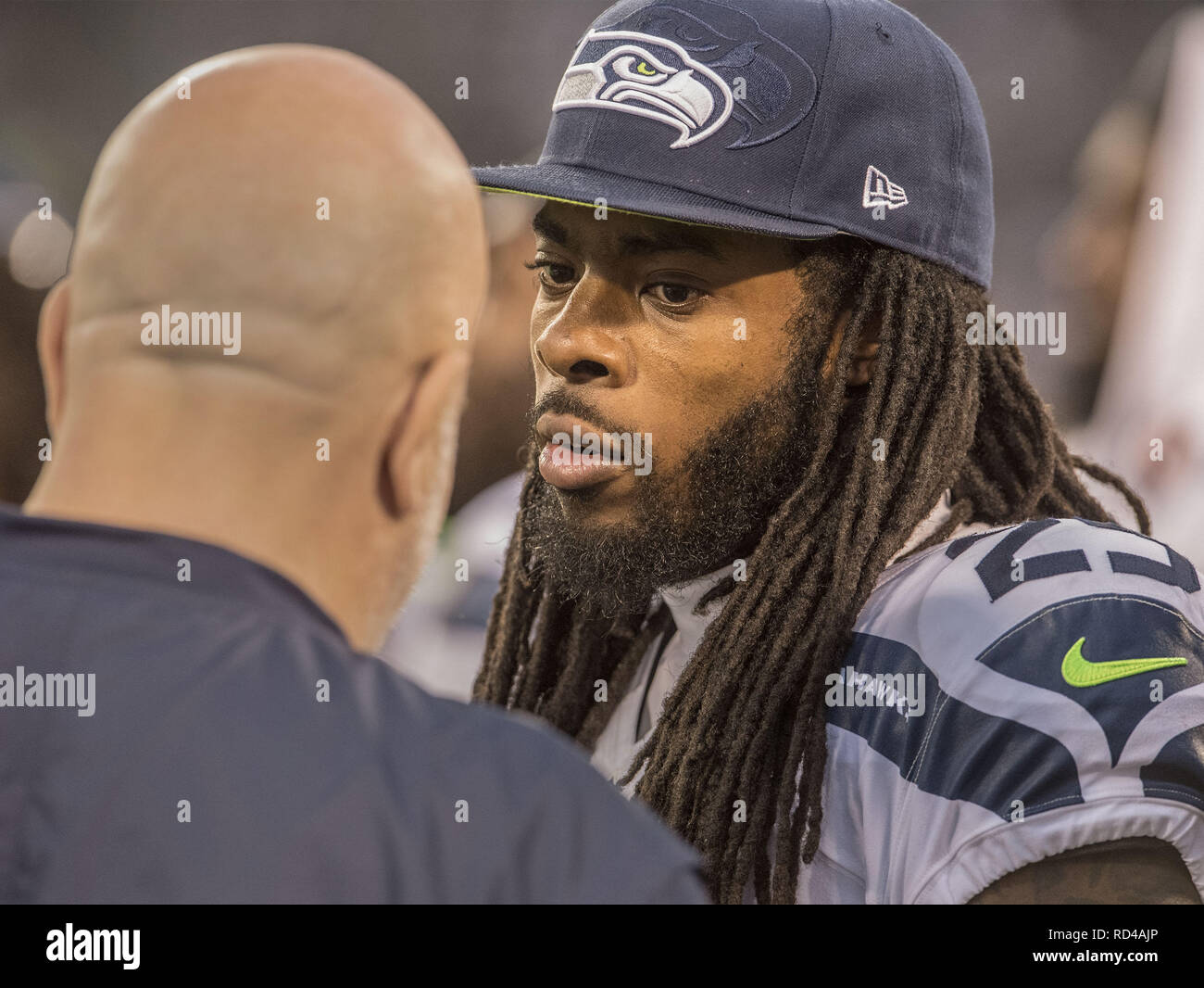 Seattle Seahawks cornerback Richard Sherman, left, begins to take off the  jersey that belongs to injured wide receiver Sidney Rice, right, after  Sherman wore it as a joke during NFL football training