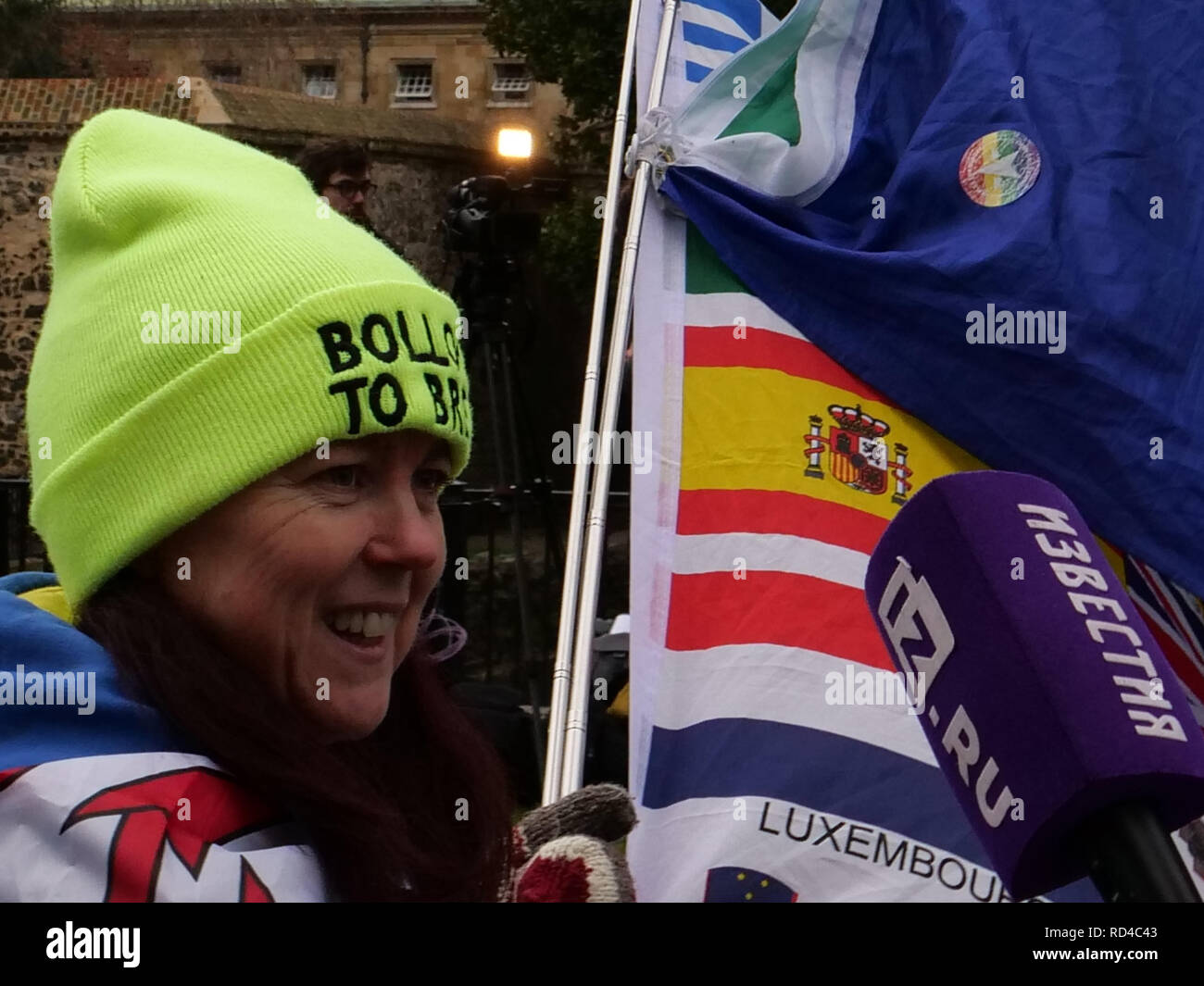 London, UK. January 16th, 2019. Anita Harris from Wales, has come to London for two days, flying the European flags near the Houses of Parliament in support of those remaining in the EU, being interviewed by one of the many foreign press reporters. Credit: Joe Kuis / Alamy Live News Stock Photo