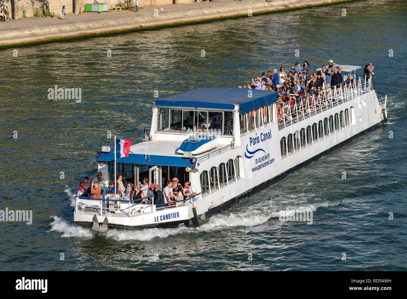 Sightseeing Boats packed with visitors and tourists admiring the sights of Paris from The River Seine .Paris Stock Photo