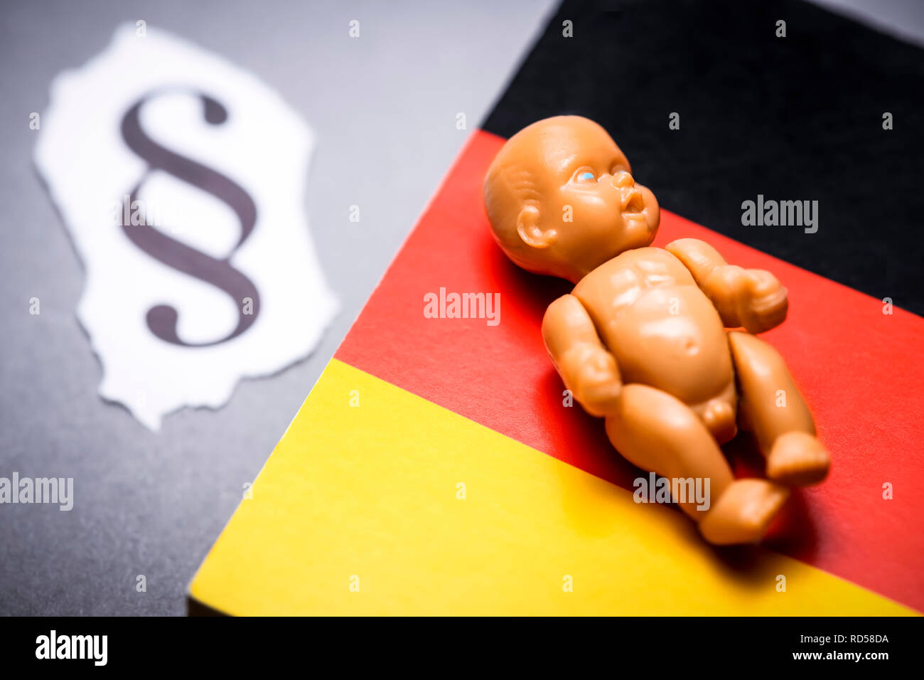 Baby figure on code, abortion law 219a, symbolic photo, Babyfigur auf Gesetzbuch, Abtreibungsparagraf 219a, Symbolfoto Stock Photo