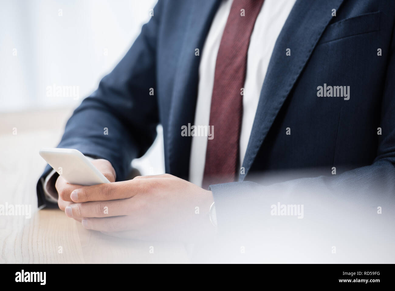 mid section of businessman in formal wear using smartphone Stock Photo