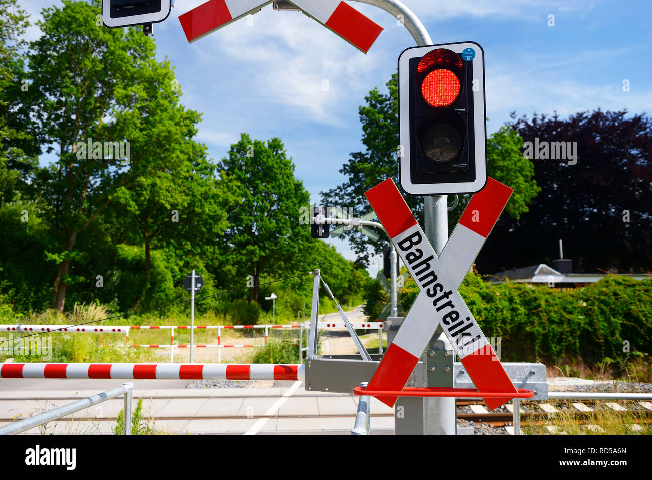 Level crossing with St Andrew's Cross and label Road strike, Photomontage, Bahnübergang mit Andreaskreuz und Aufschrift Bahnstreik, Fotomontage Stock Photo