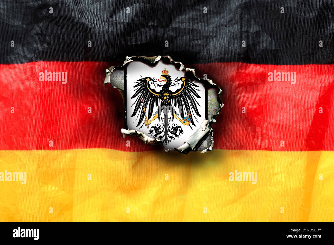 Germany flag with fire hole and imperial eagle, symbolic photo imperial citizen's movement, Deutschlandfahne mit Brandloch und Reichsadler, Symbolfoto Stock Photo