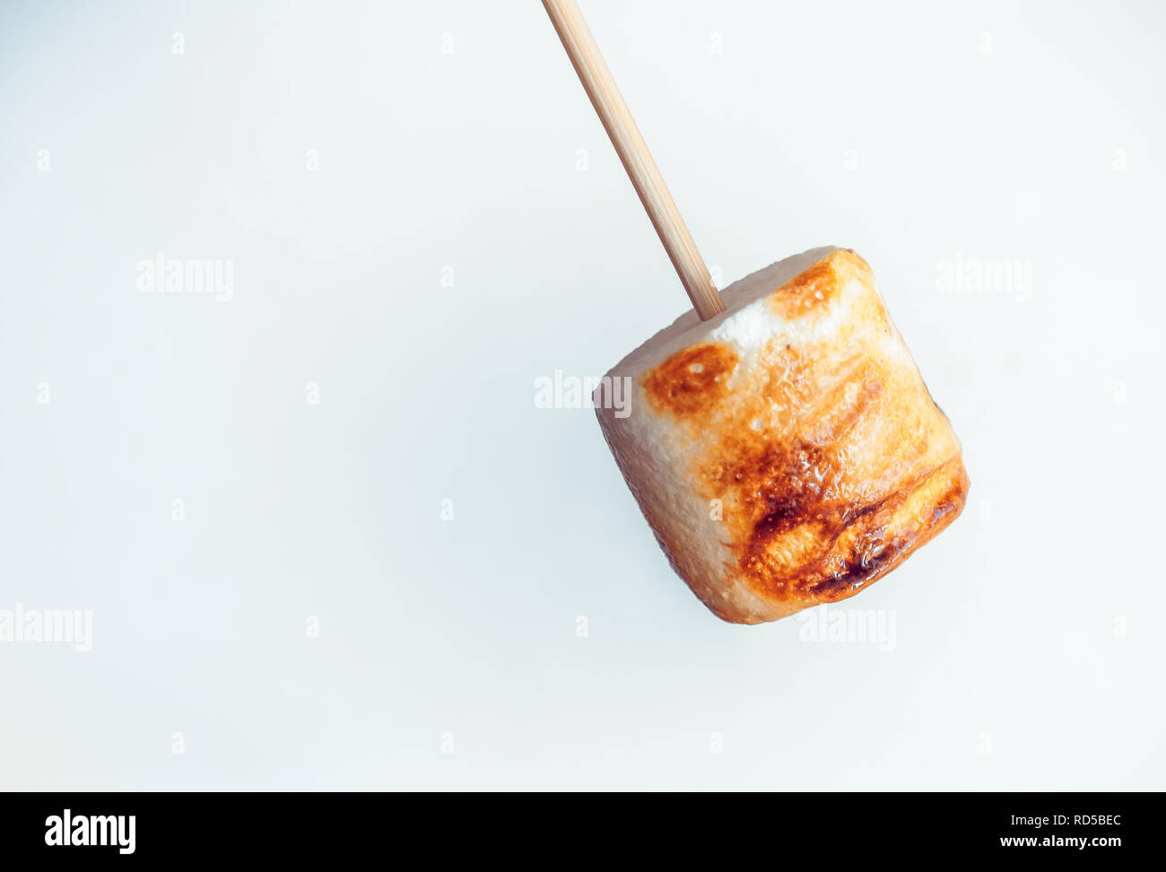 roasted marshmallows on a skewer on white background. Stock Photo