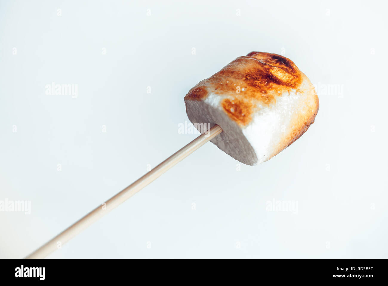 roasted marshmallows on a skewer on white background. Stock Photo