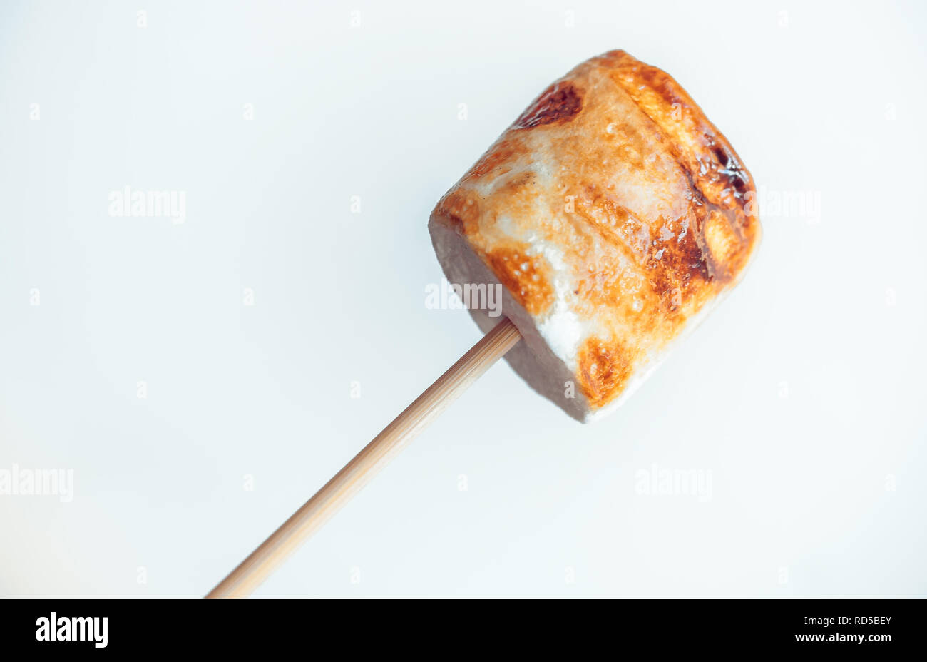 roasted marshmallows on a skewer on white background. Stock Photo