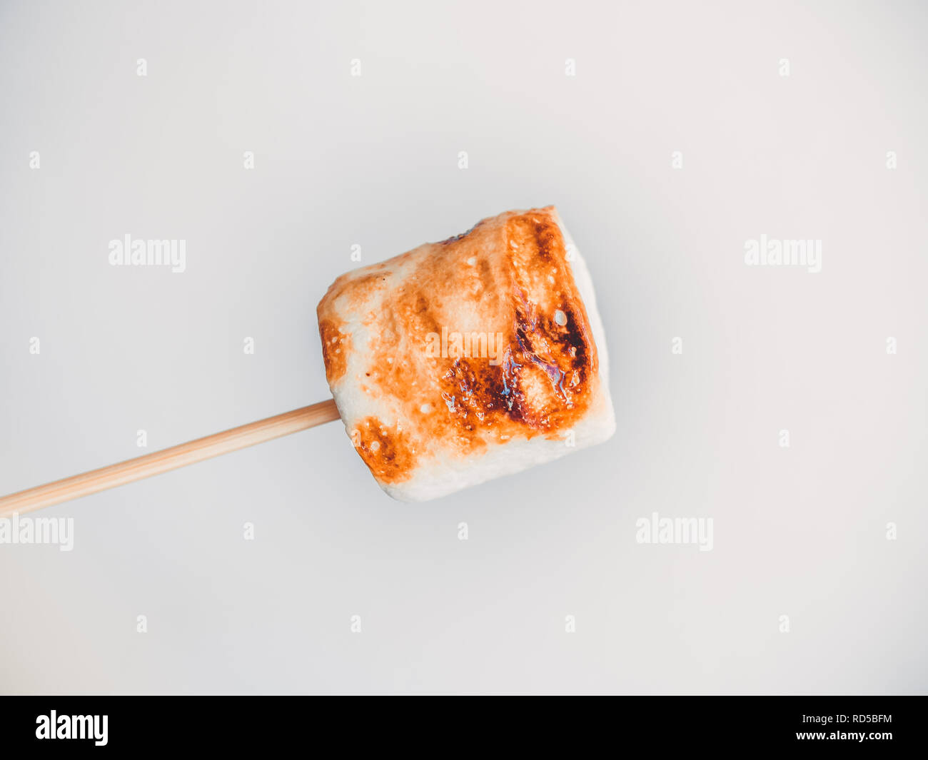 roasted marshmallows on a skewer on white background. Stock Photo