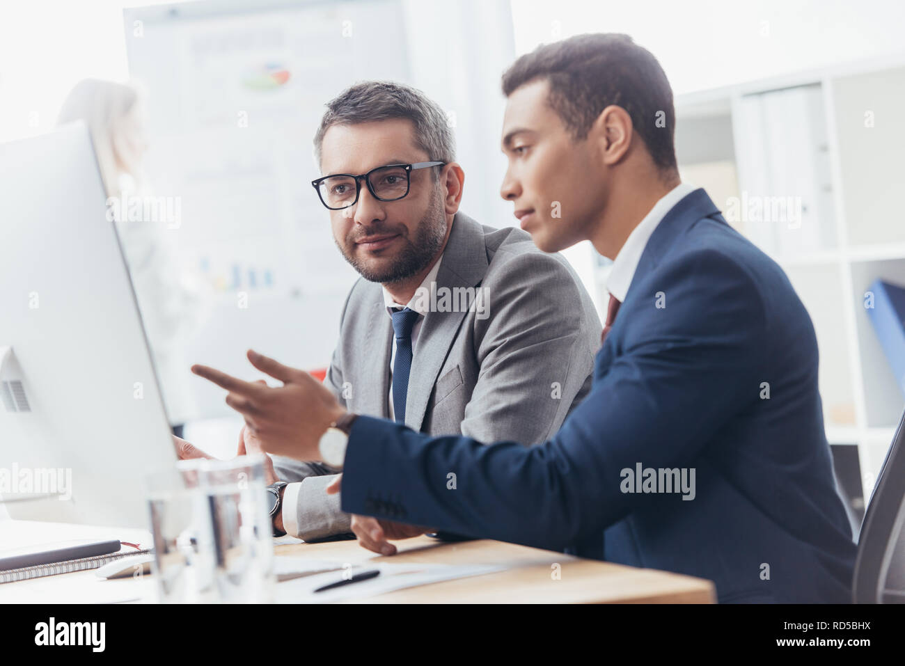 two professional businessmen discussing and using desktop computer in office Stock Photo