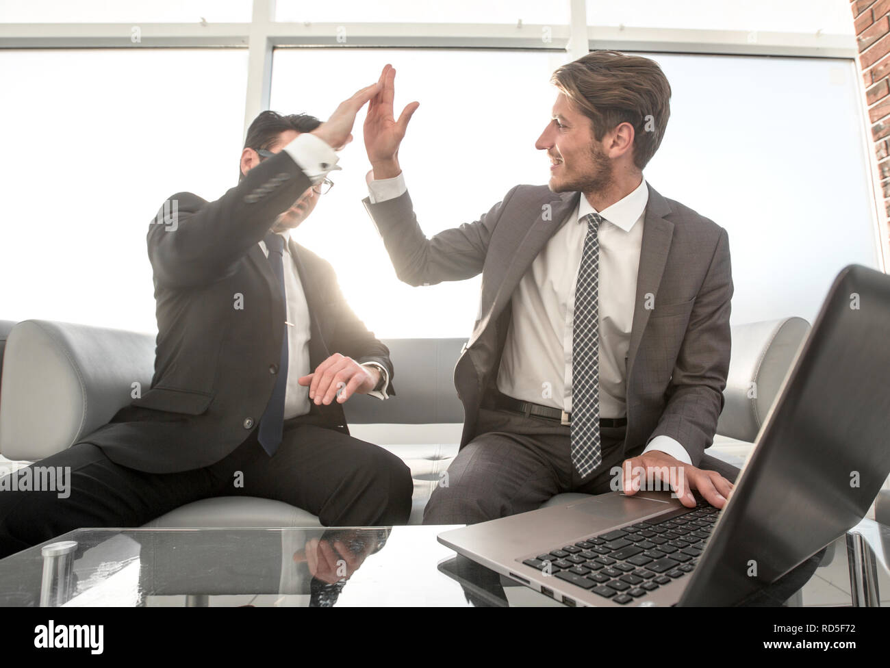 two businessmen giving each other a high five Stock Photo - Alamy