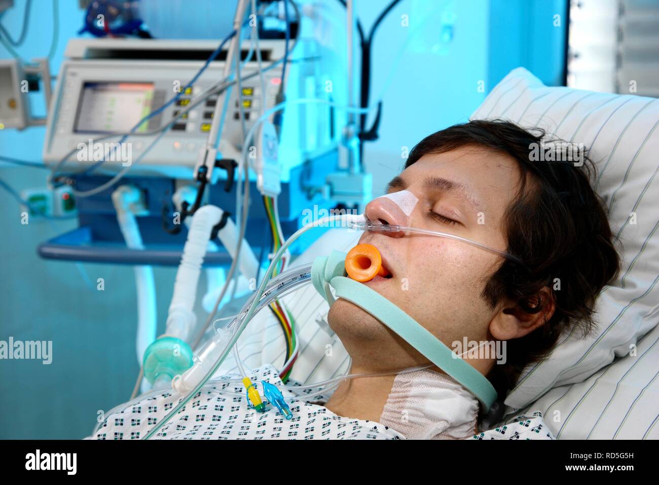 Patient lying in a special bed, intubated, medical appliances for medical treatment and artificial respiration of the patient, Stock Photo