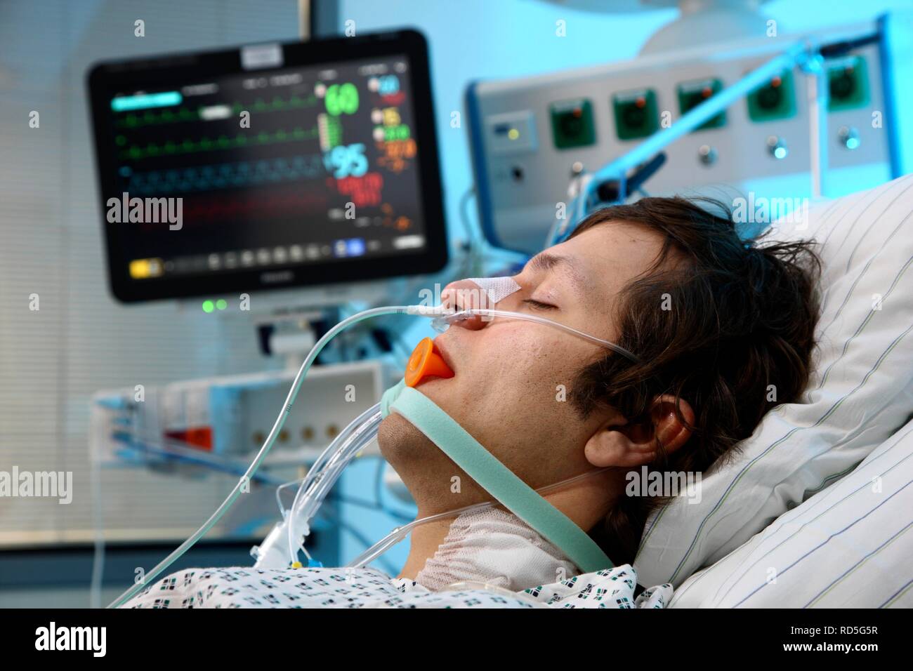 Patient lying in a special bed, intubated, medical appliances for medical treatment and artificial respiration of the patient, Stock Photo