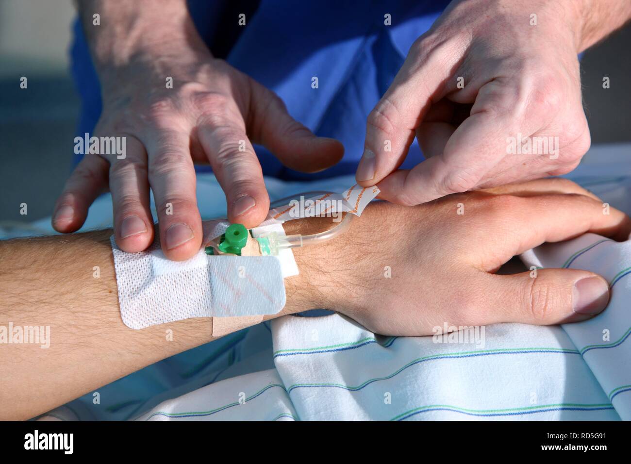 Male nurse placing a venous access, intensive care unit, hospital Stock Photo