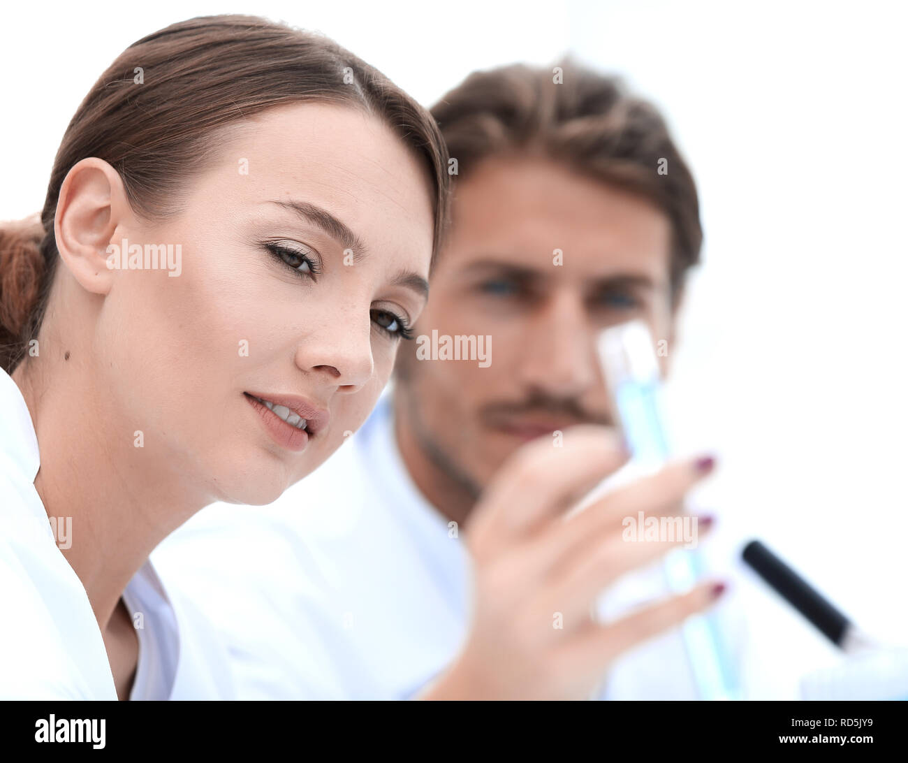 Woman looking at test tubes with colorful liquids Stock Photo