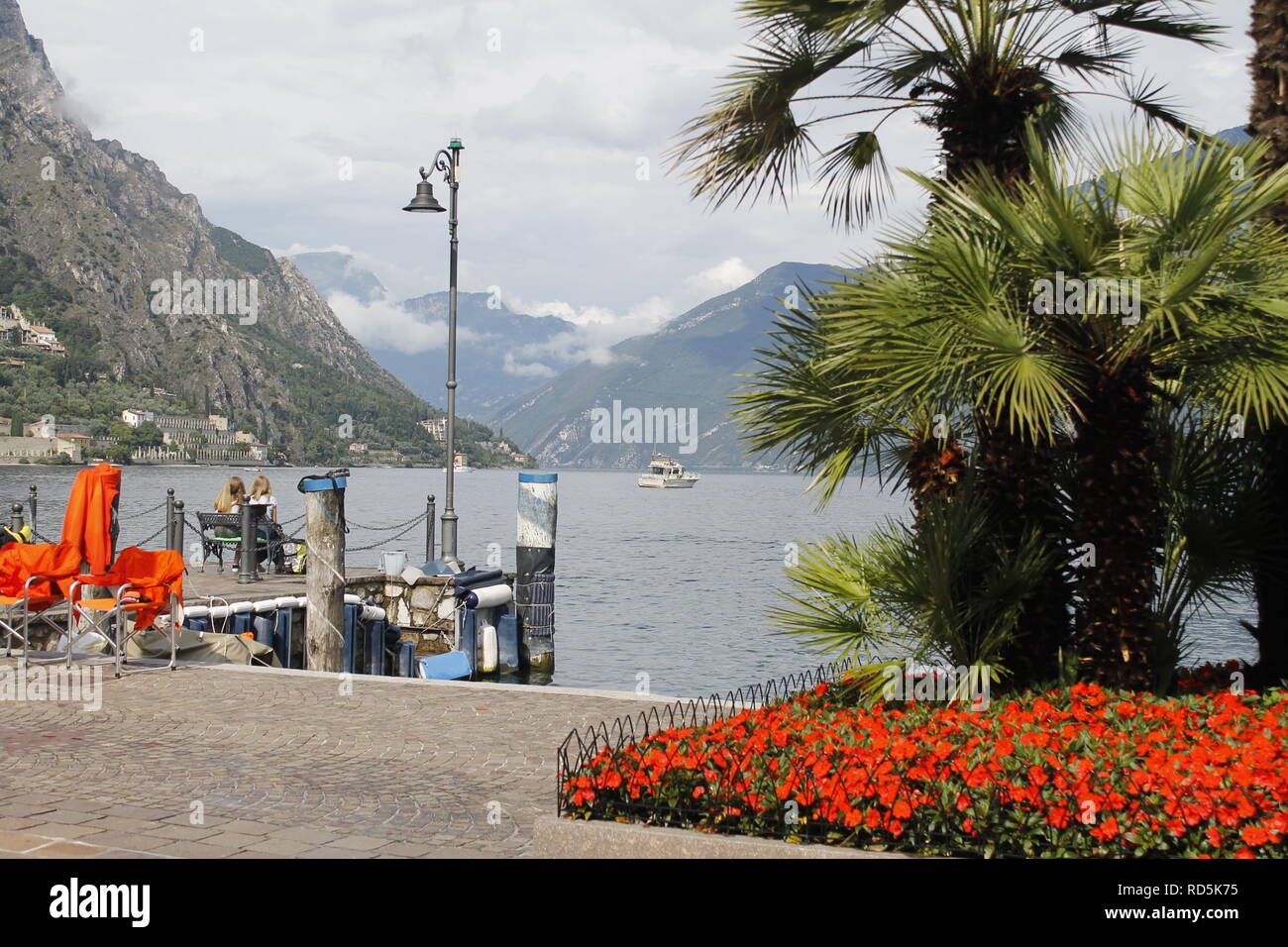 Walkway with colorful flowers on Garda lake in Italy. Stock Photo