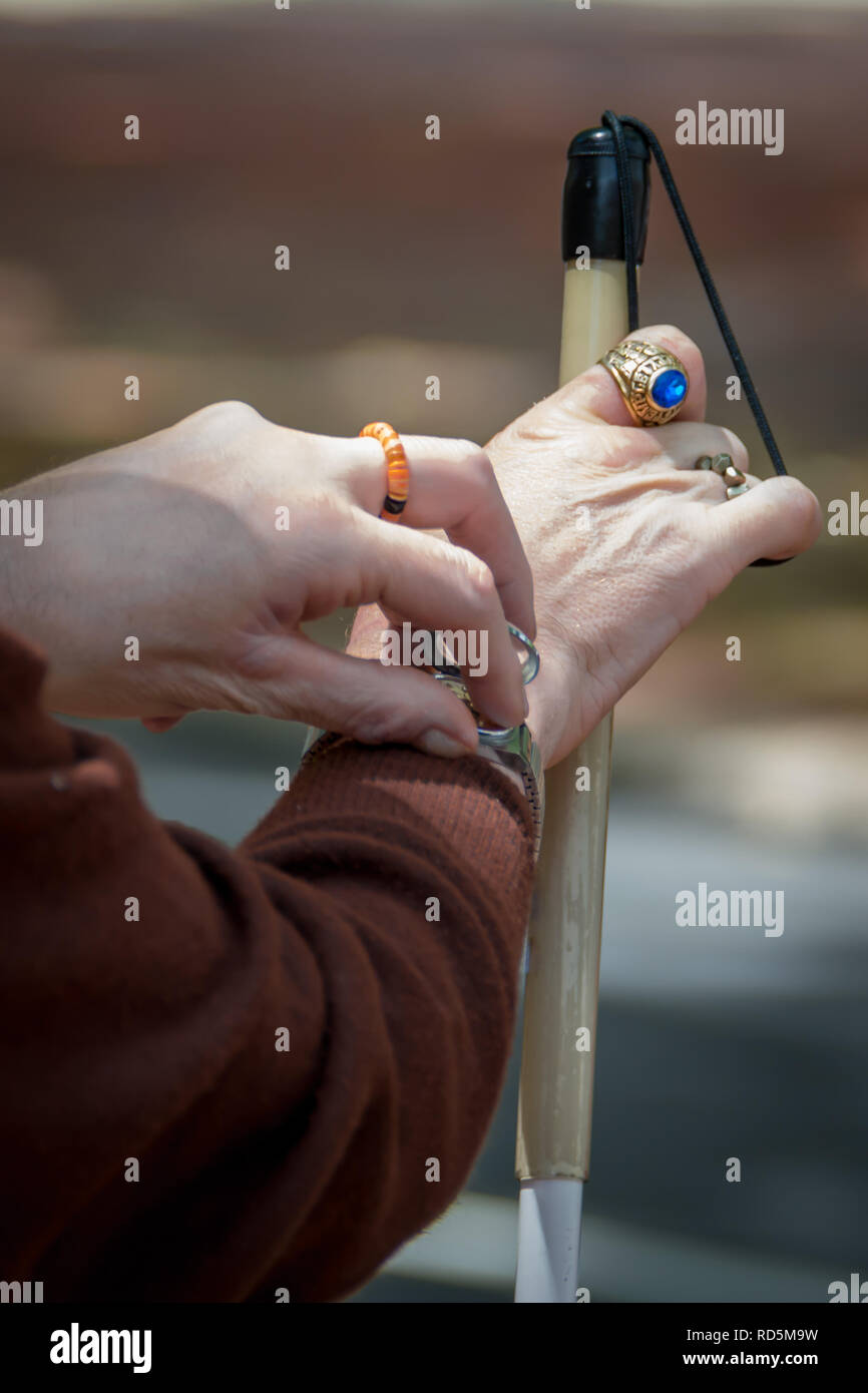 Blind man checking his watch at the bus stop Stock Photo