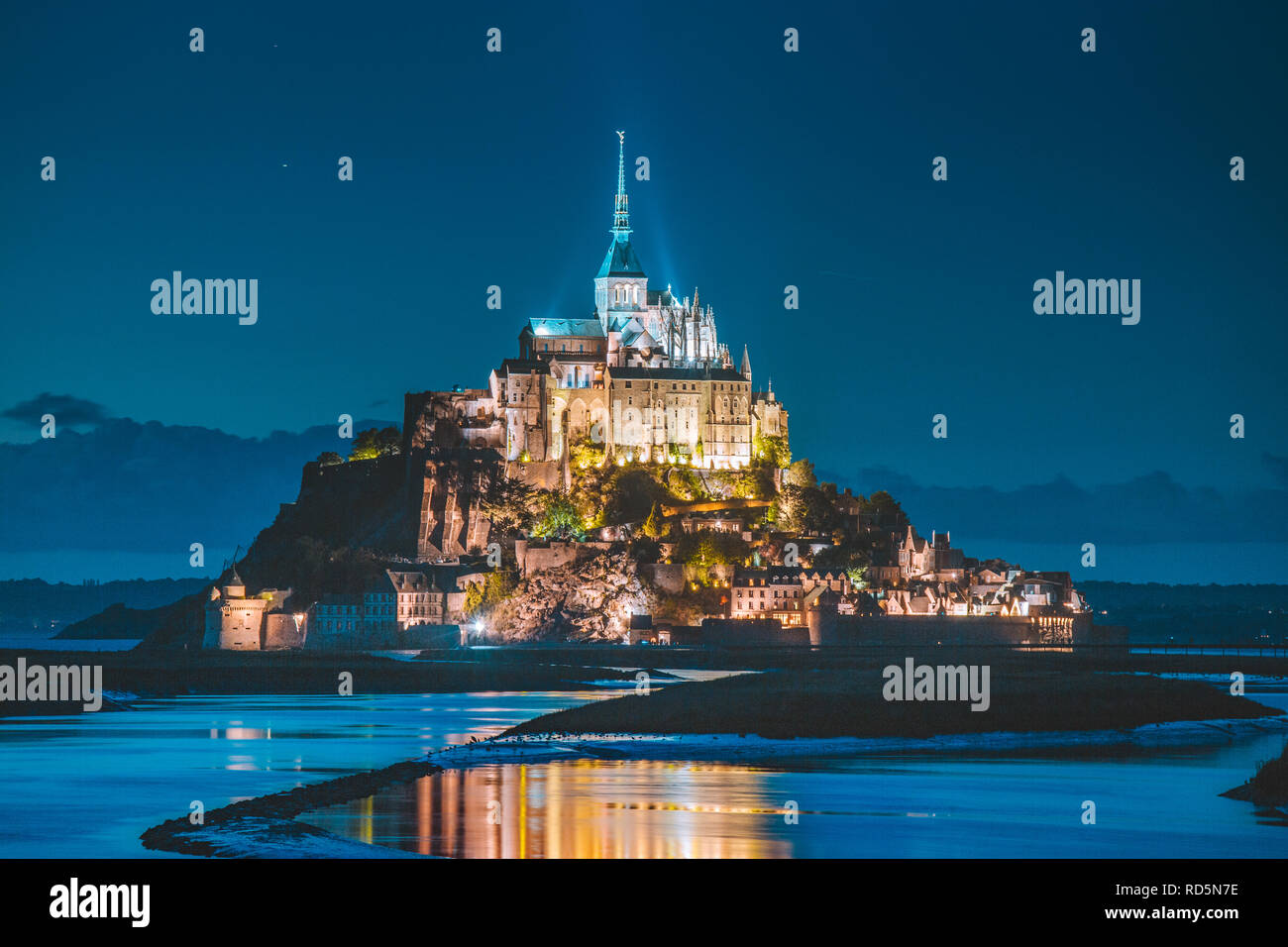 Classic view of famous Le Mont Saint-Michel tidal island in beautiful twilight during blue hour at dusk, Normandy, northern France Stock Photo