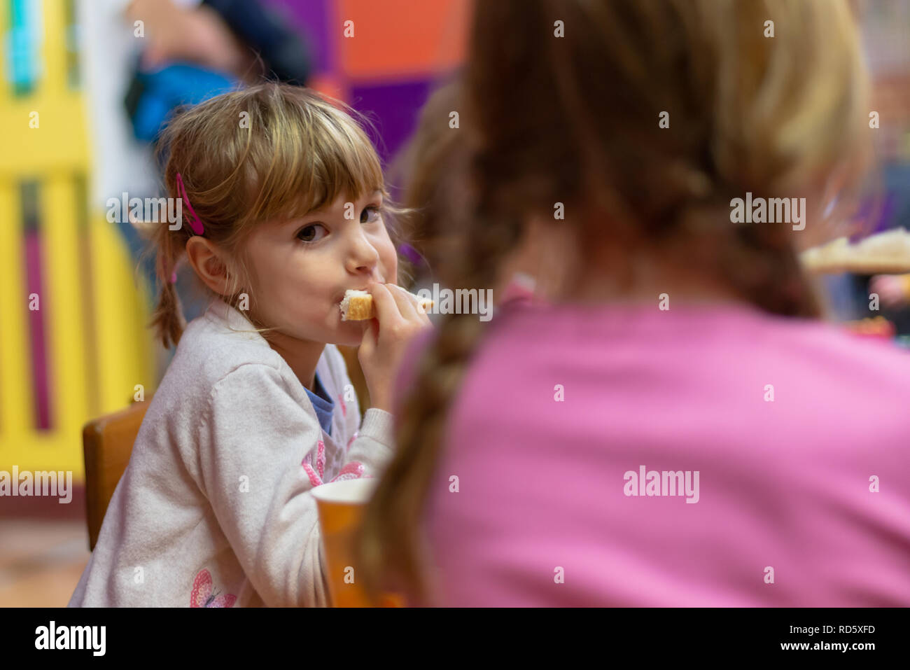 Girl eating sandwich at birthday party Stock Photo