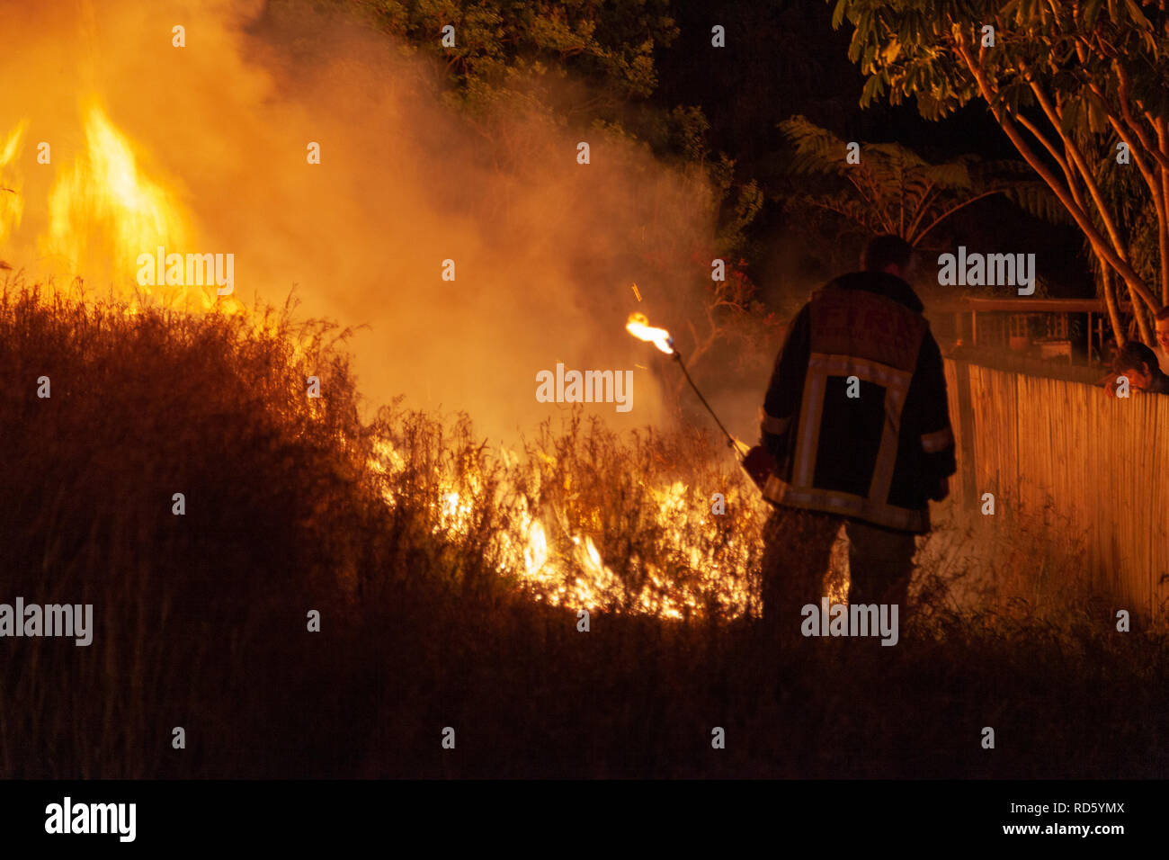 Teralba, NSW/Australia October 24, 2012 Fireman or firefighter backburning and extinguishing