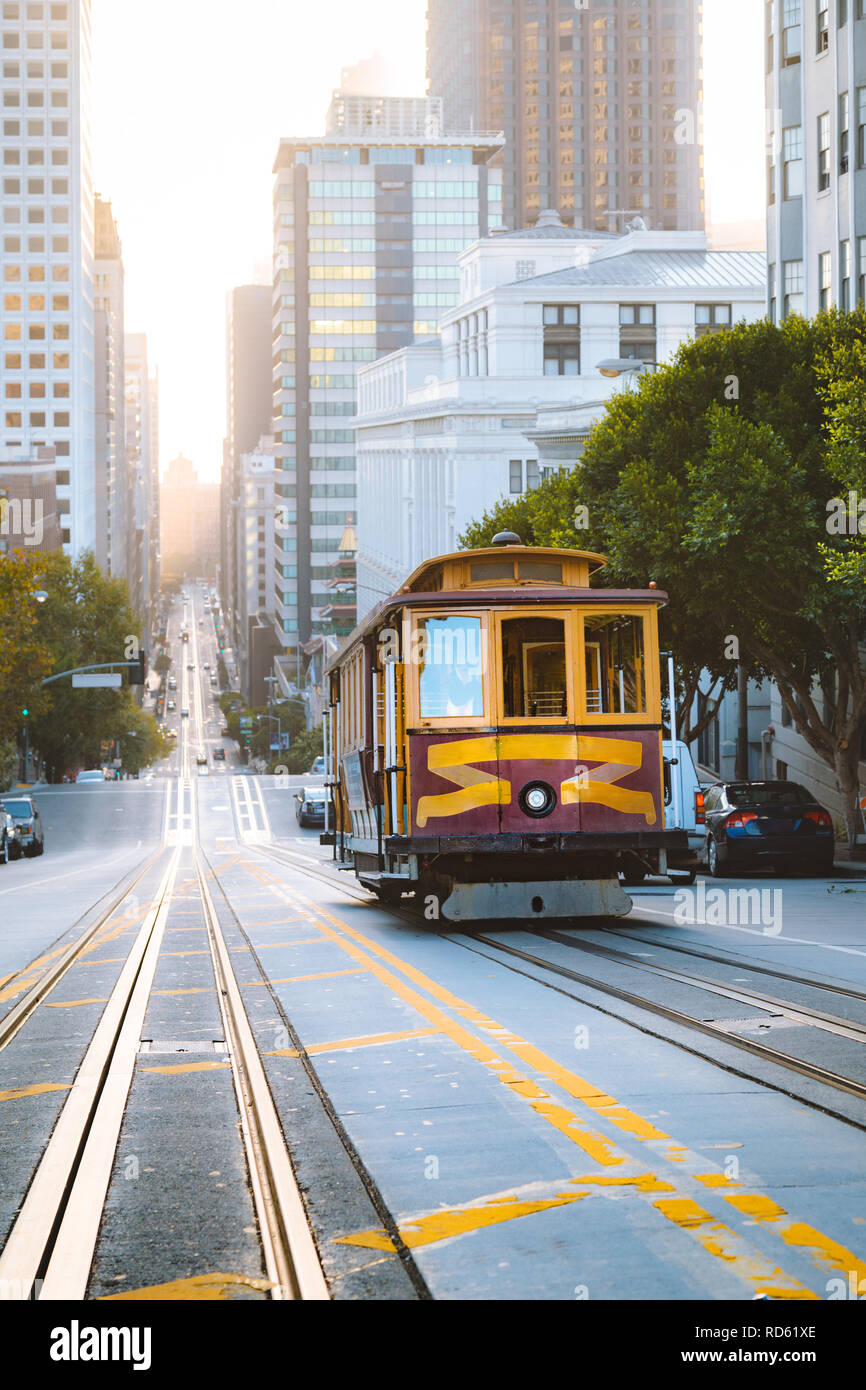 Historic Cable Cars riding on famous California Street in beautiful golden morning light at sunrise, San Francisco, California, USA Stock Photo