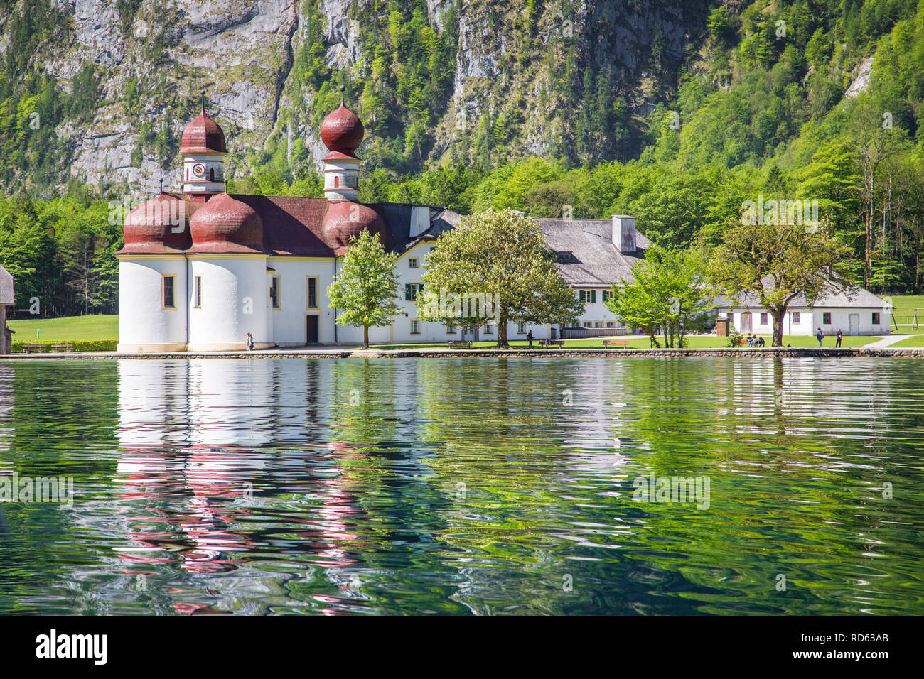 Classic view of Lake Konigssee with world famous Sankt Bartholomae pilgrimage church and Watzmann mountain on a beautiful sunny day in summer Stock Photo