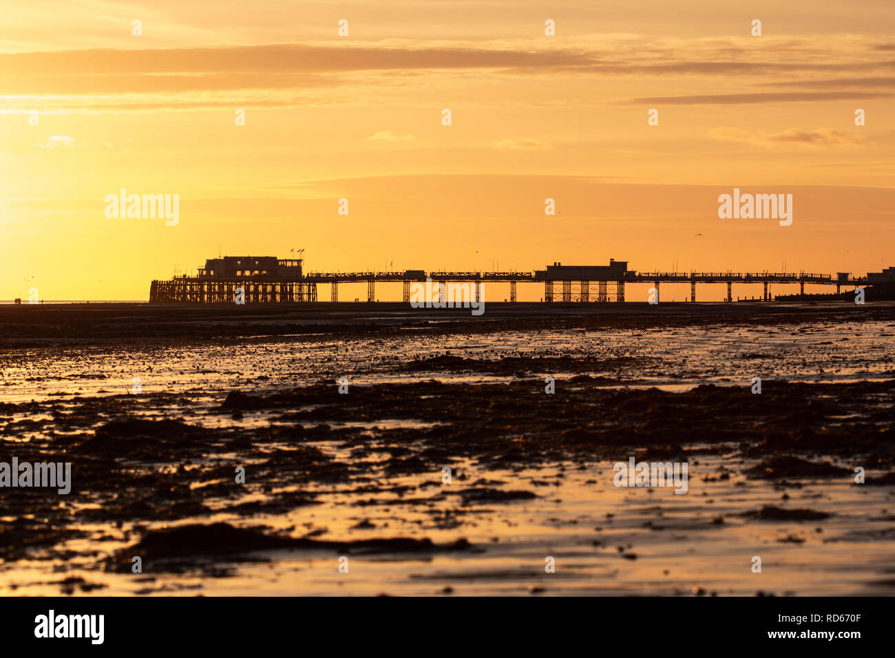 Worthing pier set against an orange sky Stock Photo