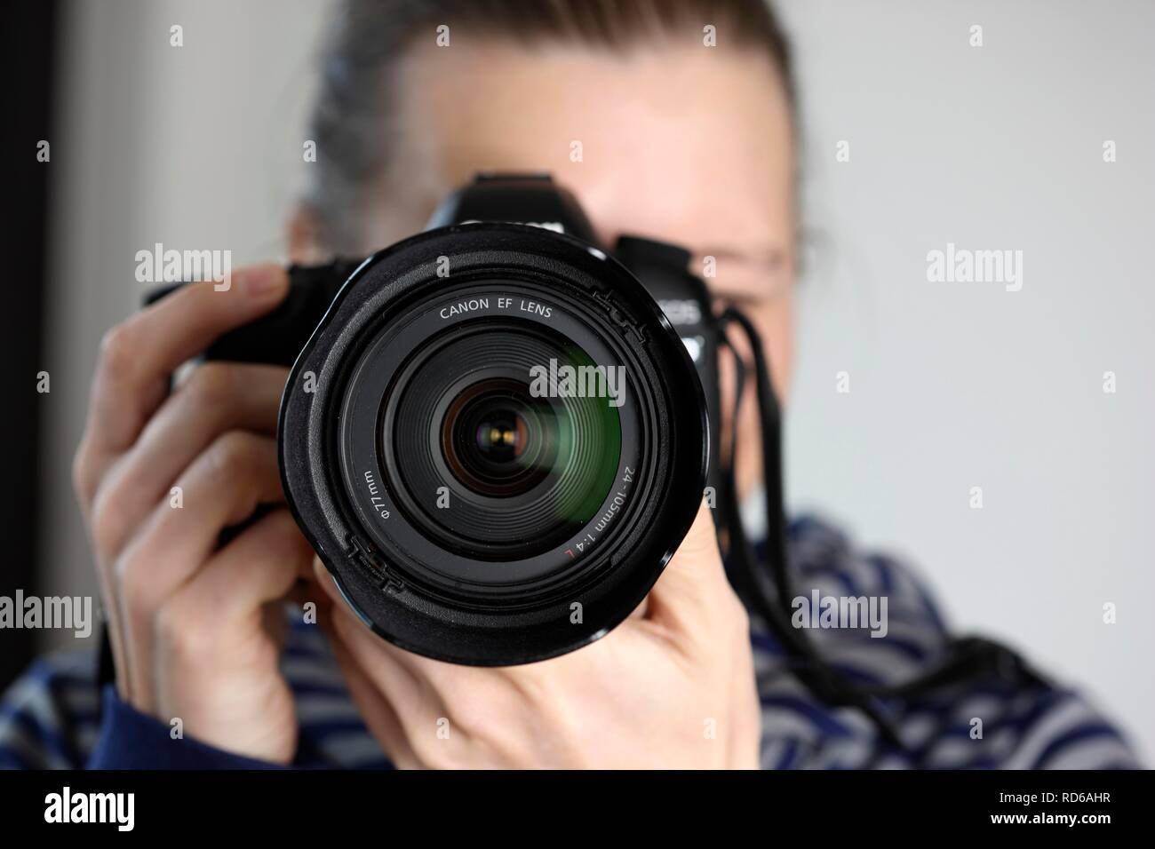 Woman looking through the viewfinder of a digital SLR camera Stock Photo