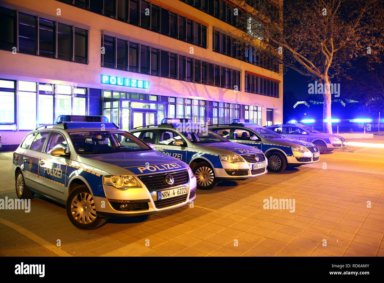 Police car driving off with flashing lights, patrol cars parked in front of a modern police station, Gelsenkirchen Stock Photo