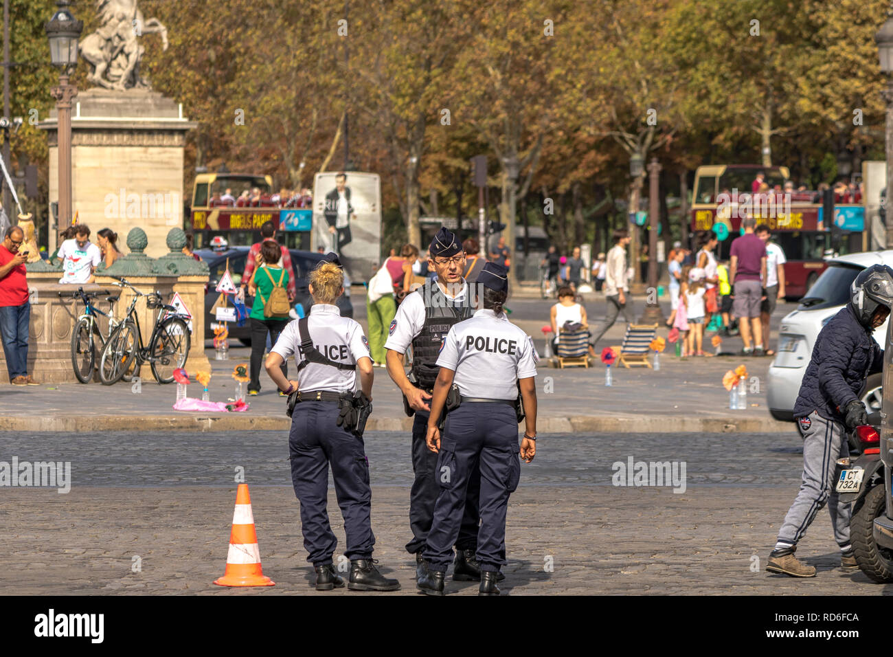 Male and female officers of the Police Nationale talk amongst themselves while on traffic duty on Place de la Concorde , Paris France Stock Photo