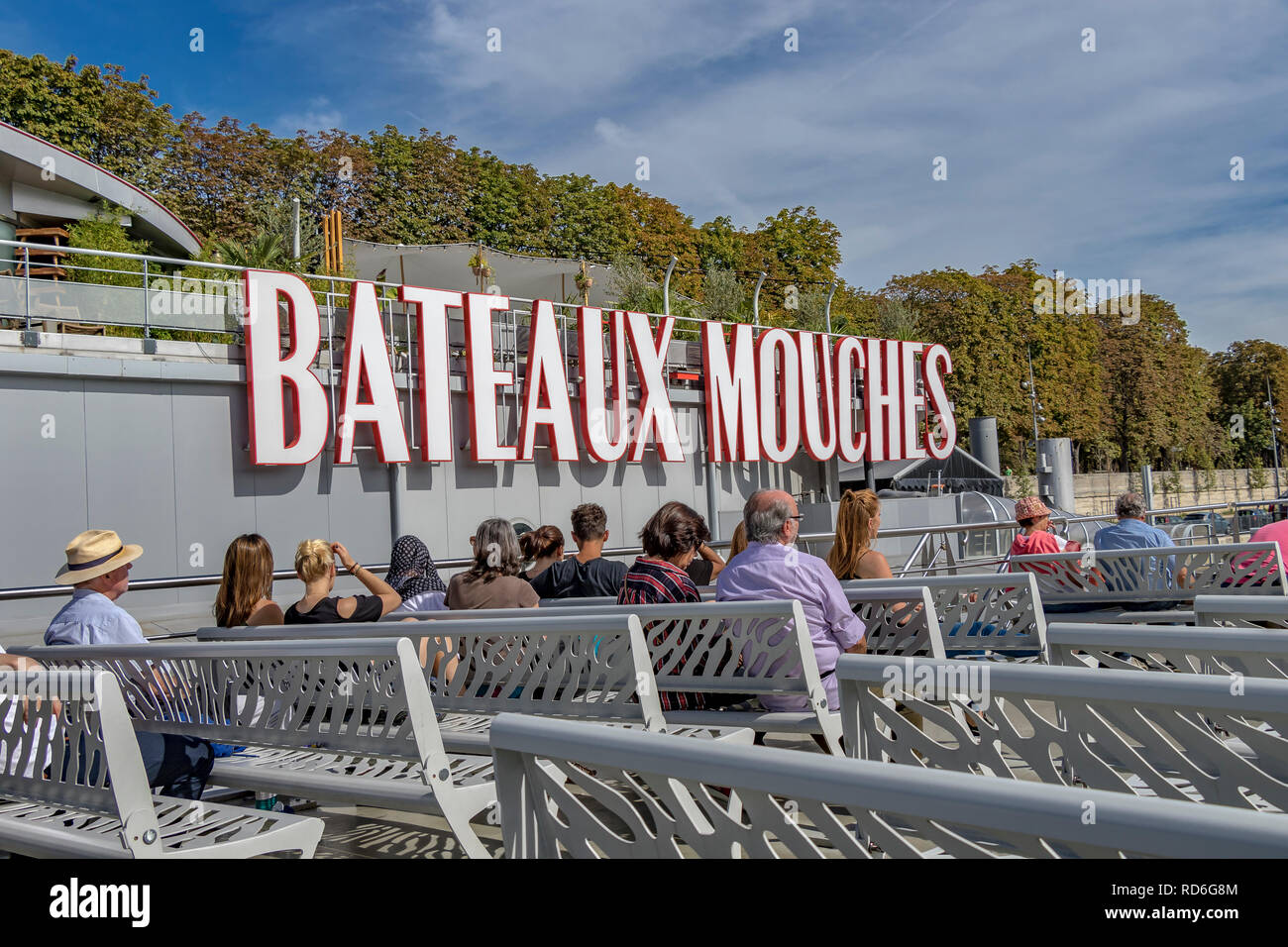 Tourists and visitors on board a Bateaux Mouches River Seine sightseeing cruise on a warm summer's day in Paris Stock Photo