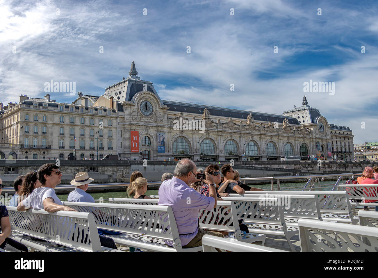 Tourists and visitors on board a Bateaux Mouches River Seine sightseeing cruise , pass by The Musée d'Orsay on a warm summer's day in Paris Stock Photo