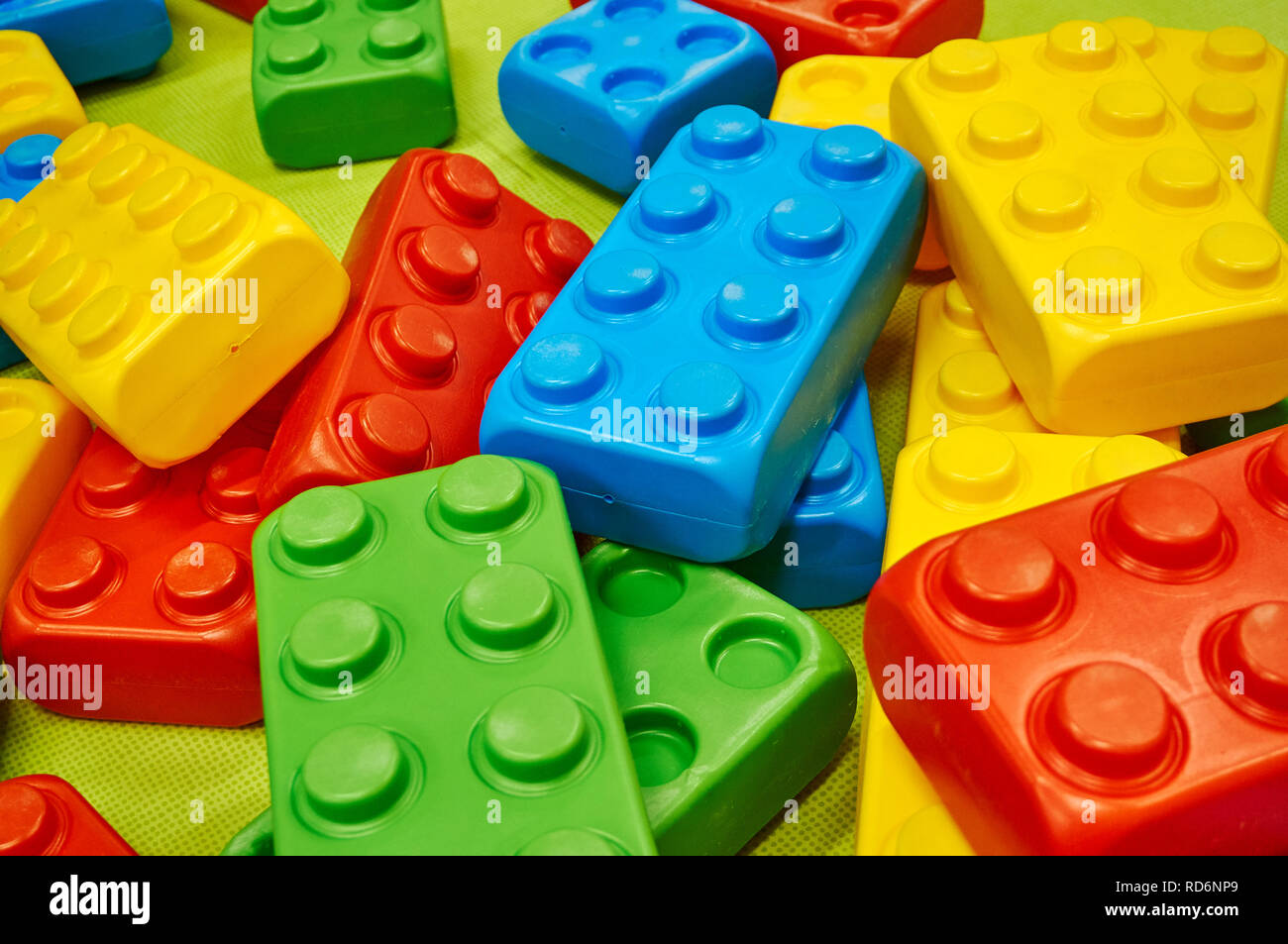 Oversized children's colorful plastic building blocks scattered on the floor. Stock Photo