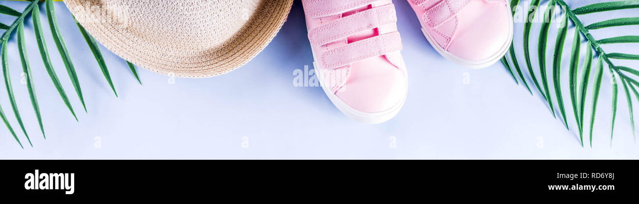 Colorful summer vacation and holiday flat-lay. Straw hat, sunglasses, palm and monstera leaves on bright blue yellow background, top view, copy space  Stock Photo