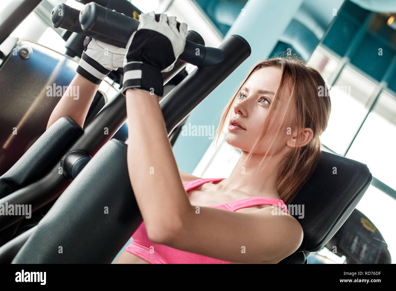 Sports Young Woman Doing Exercises on Trainer Back Machine in the