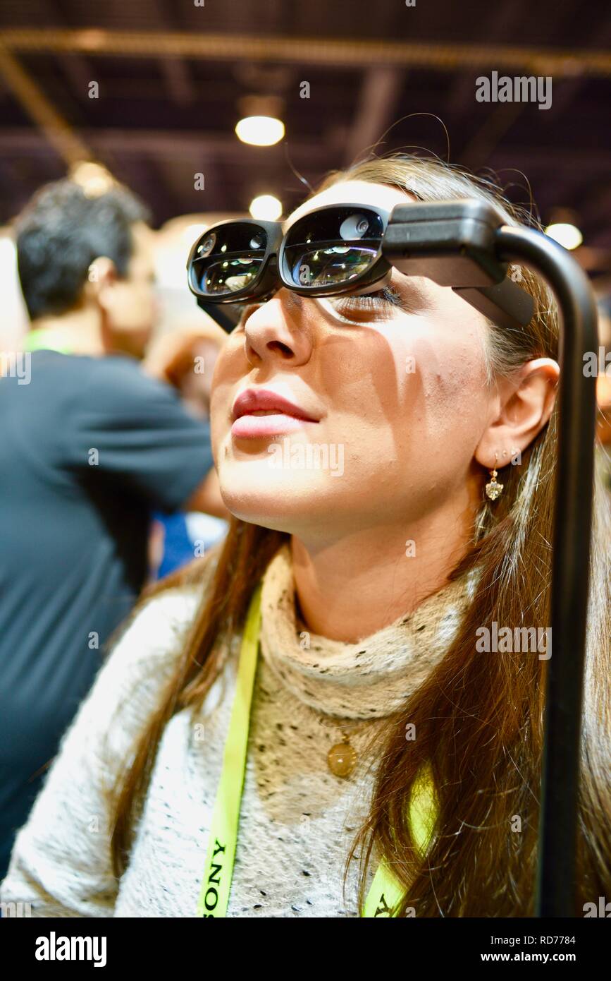 Female CES (Consumer Electronics Show) attendee viewing mixed reality on Mixed Reality nreal glasses at CES, held in Las Vegas, USA. Stock Photo