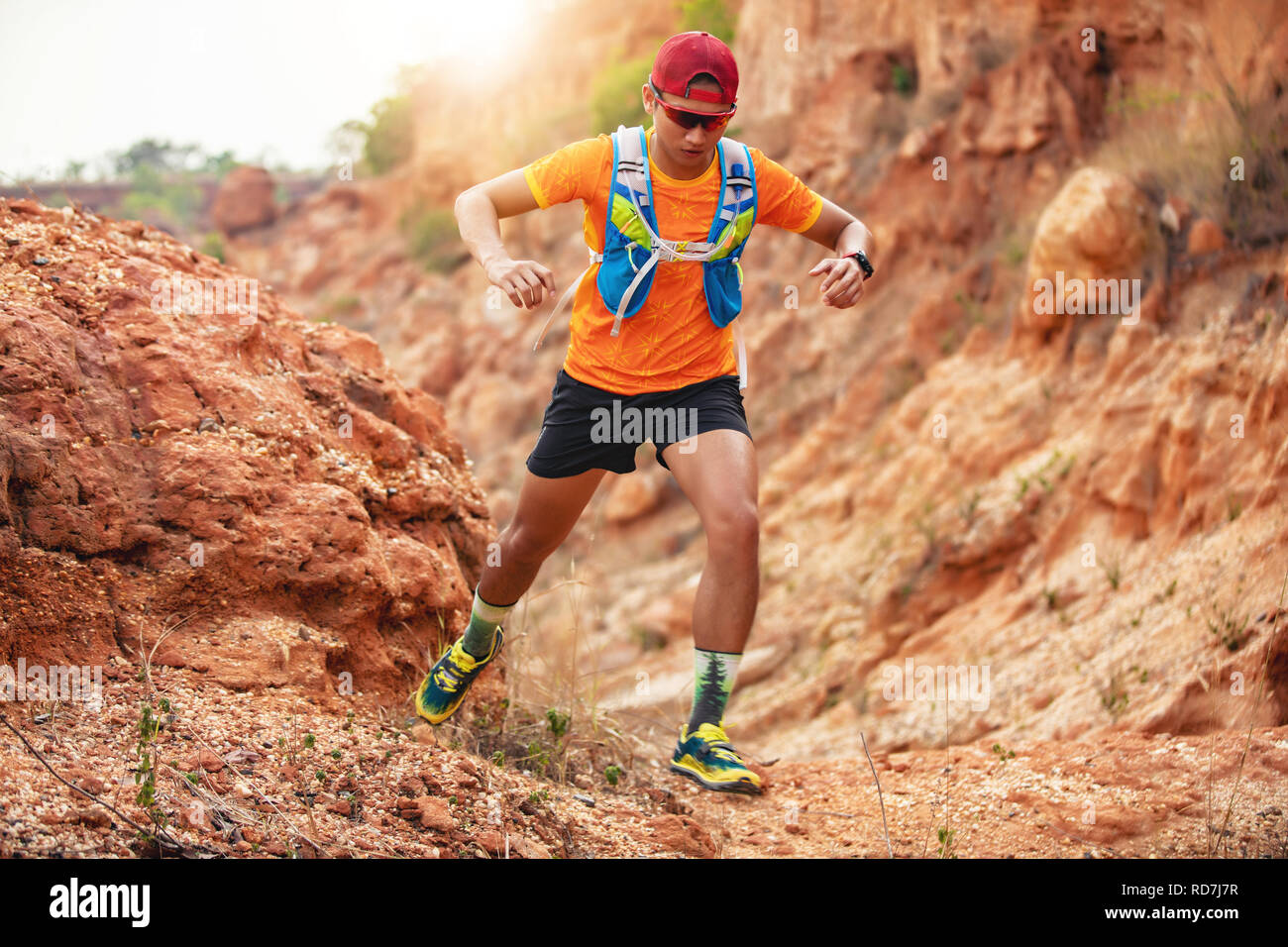 male runner in compression calf sleeve run over rocks Stock Photo