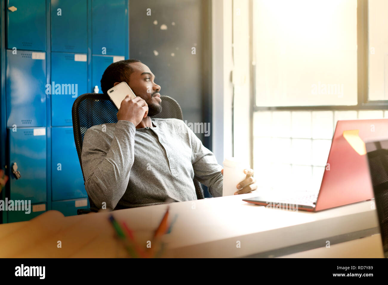 Attractive young black man working in modern office space Stock Photo