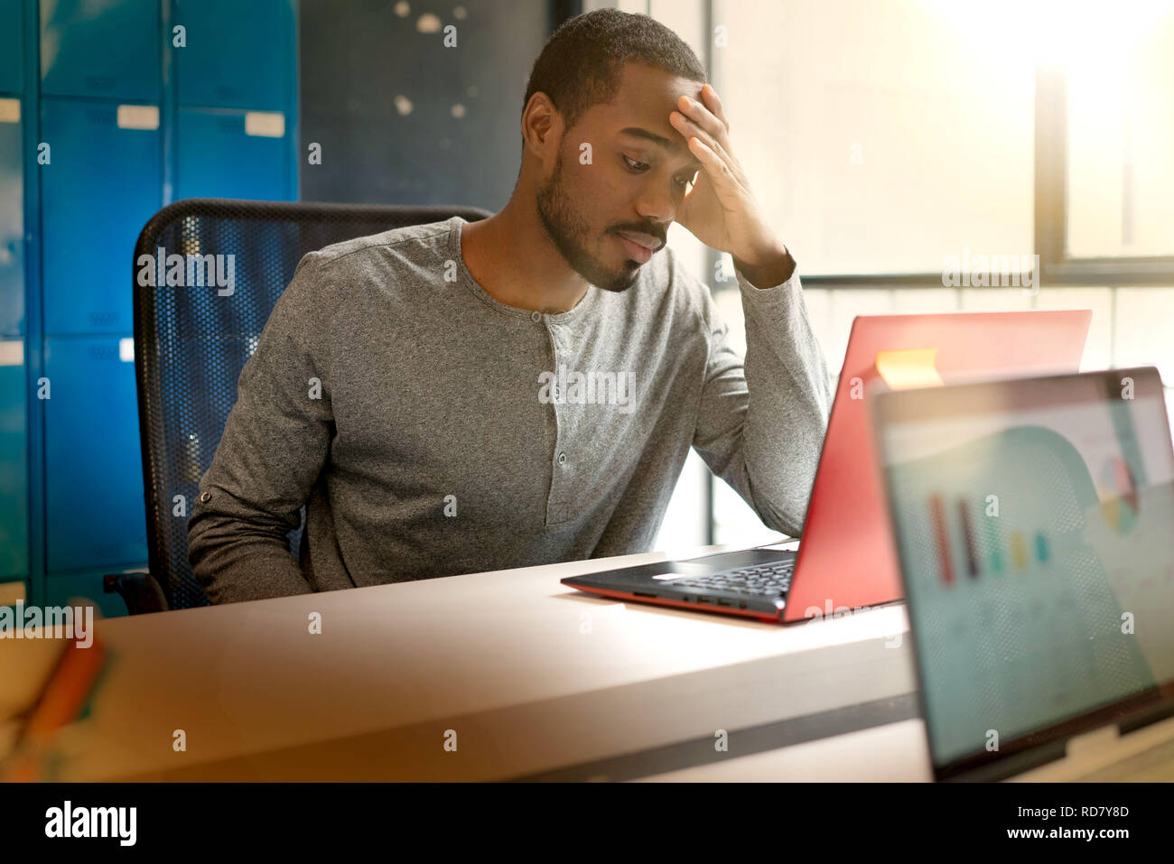 Attractive young black man working in modern office space Stock Photo