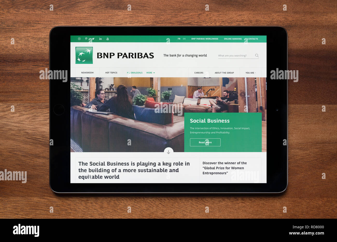 The website of BNP Paribas is seen on an iPad tablet, which is resting on a wooden table (Editorial use only). Stock Photo