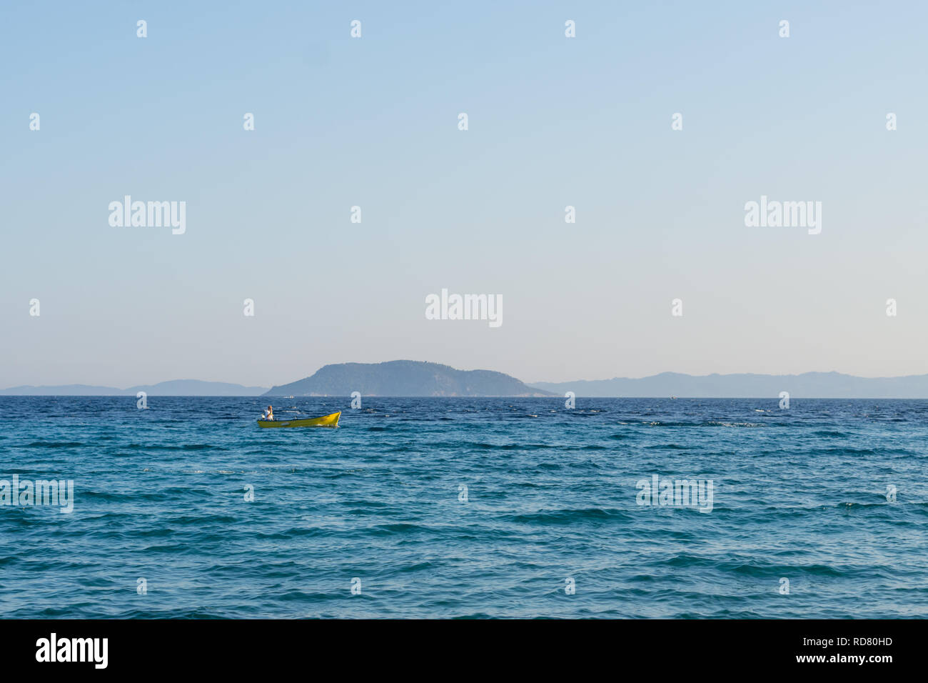 Small yellow motorized boat with one man sails in the open sea Stock ...