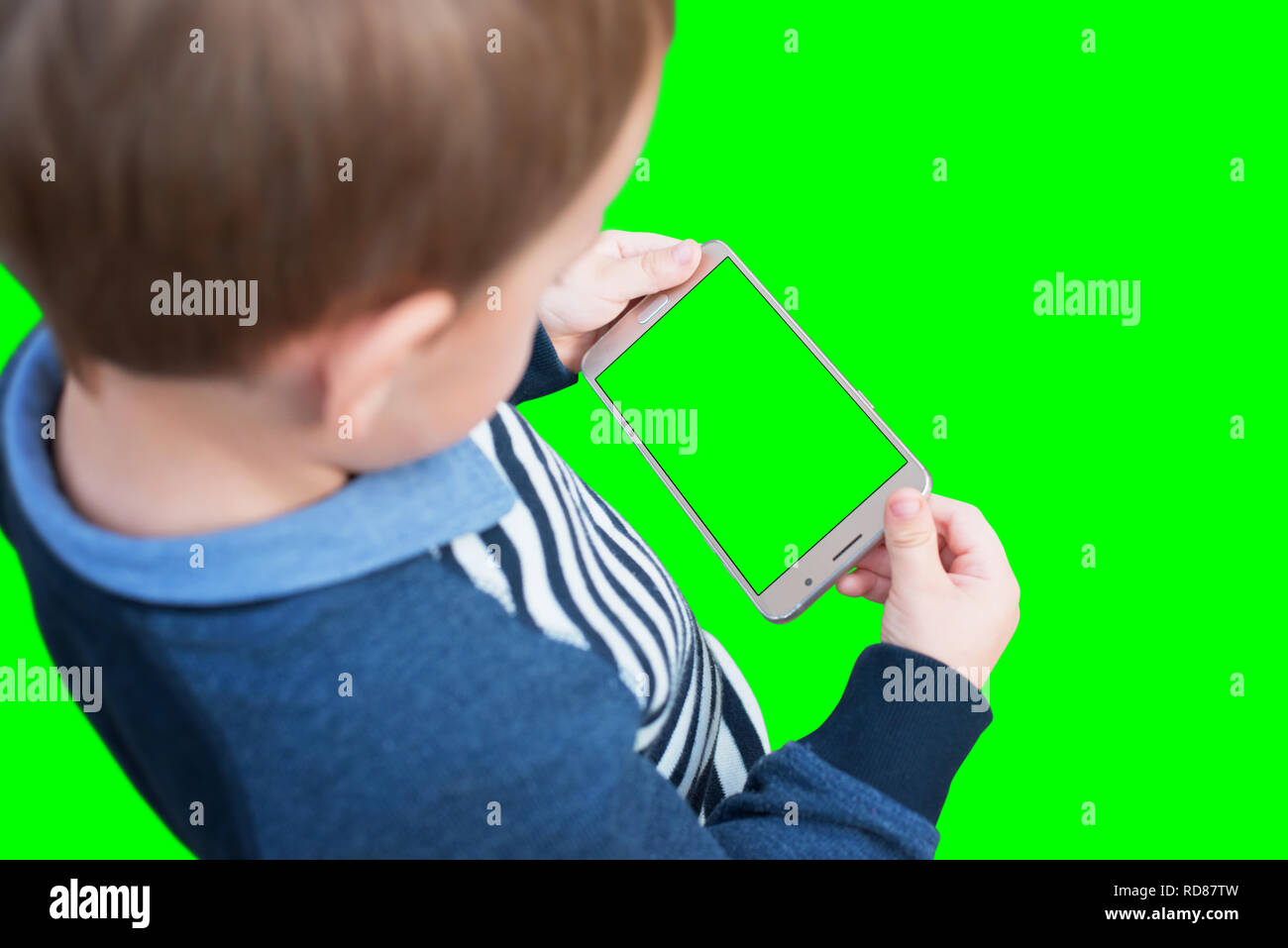 Kid holding smart phone in horizontal position. Isolated screen and background in green, chroma key. Stock Photo
