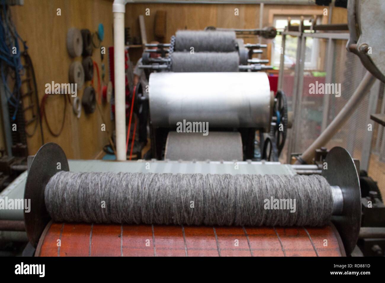 Wool thread being spun from raw wool product , part of process to ...