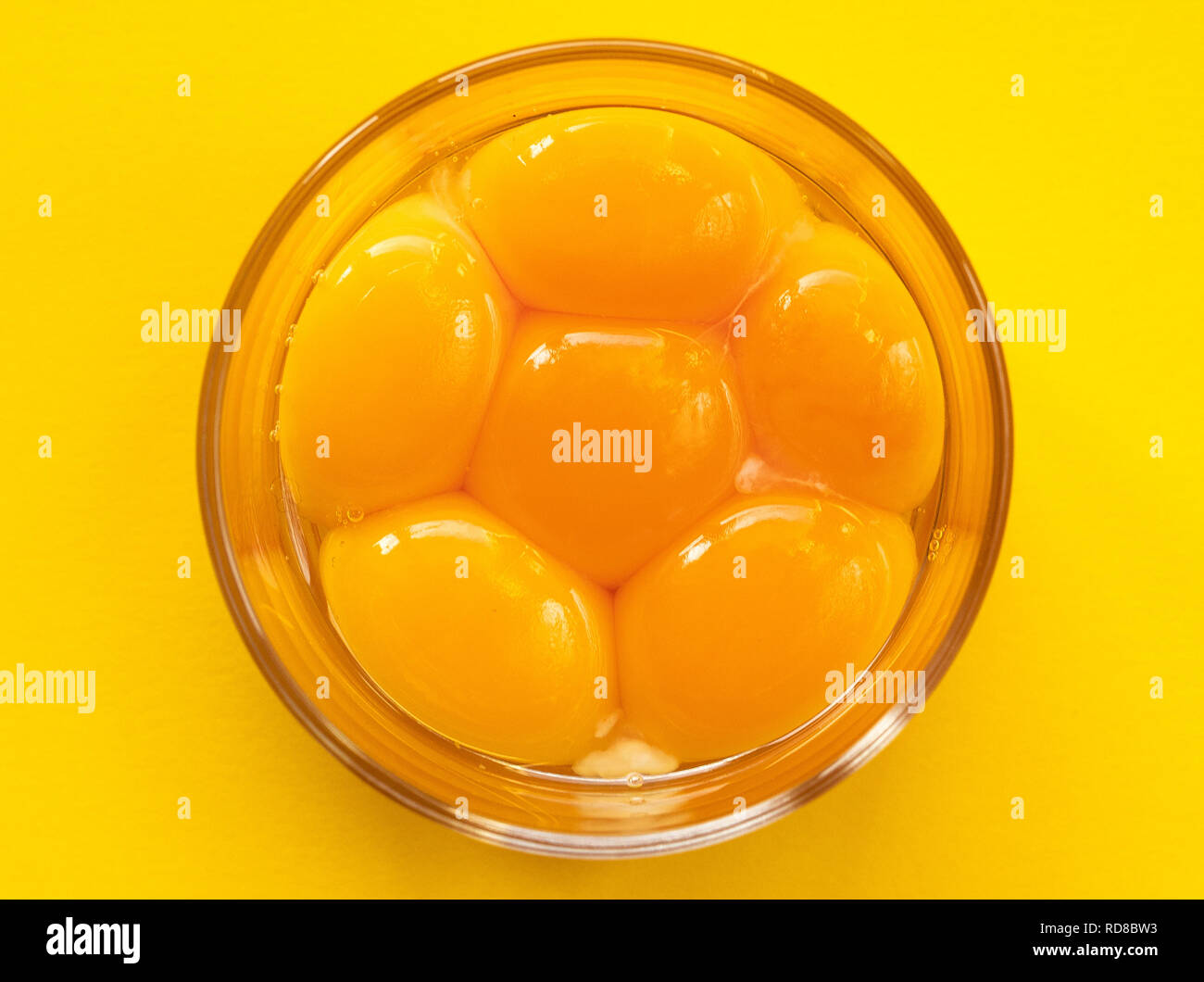 Six raw eggs in a glass bowl with beaters near yolk Image, isolated