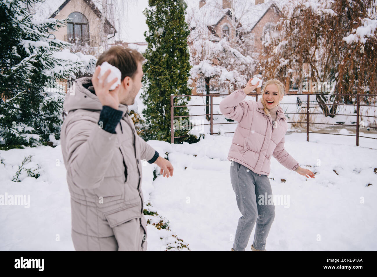 cheerful couple playing with snowballs in winter Stock Photo - Alamy