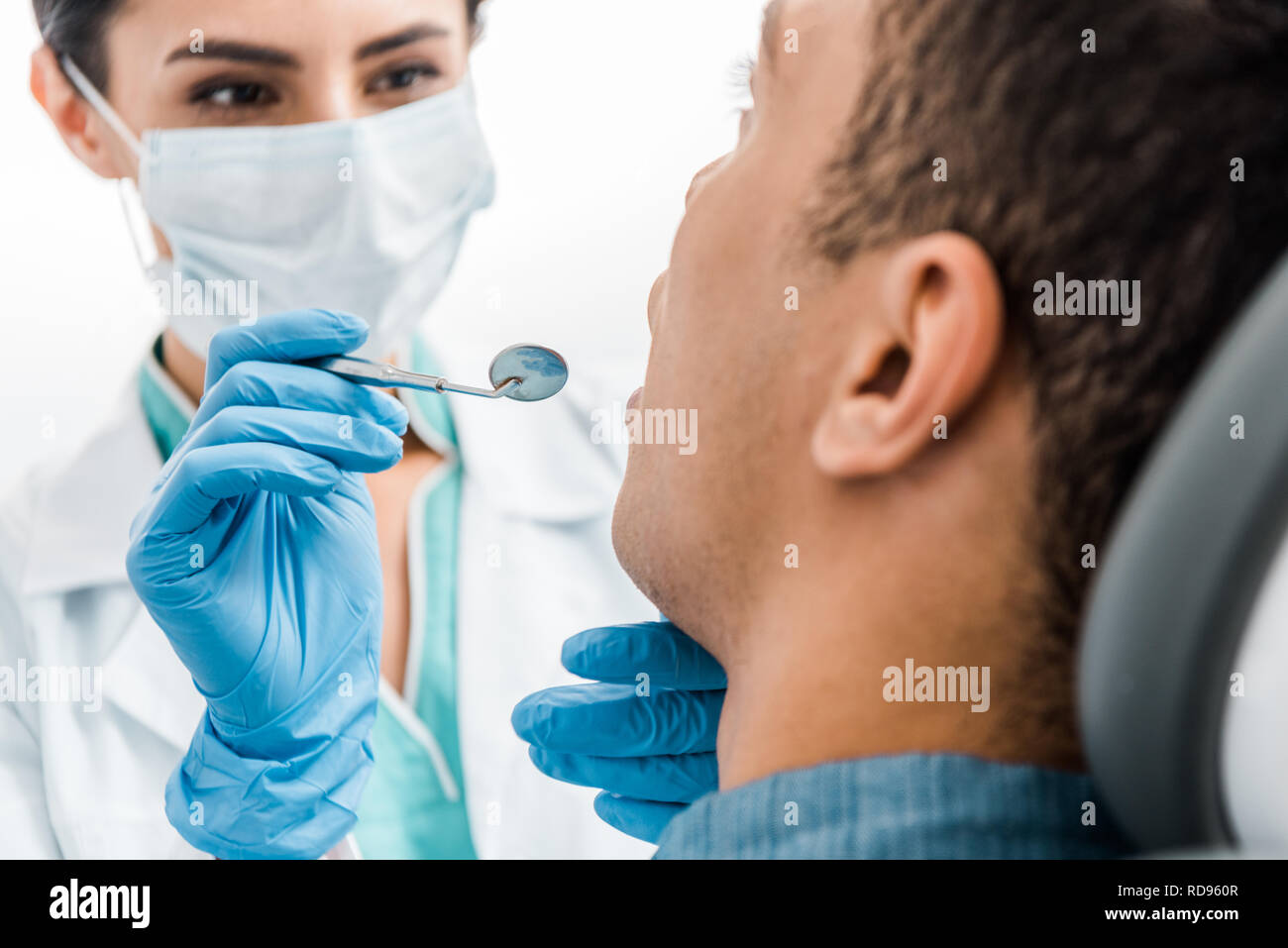selective focus of female hands of dentist in latex gloves examining