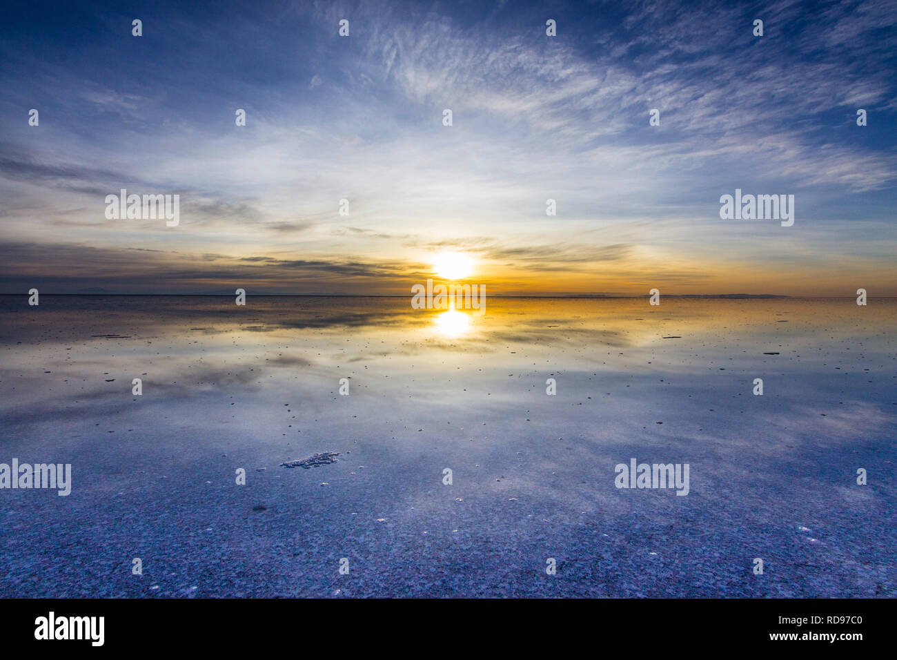 Salar de Uyuni sunrise reflections. An amazing nature landscape inside a wild environment at Uyuni salt flats.  A blue natural colorful background Stock Photo