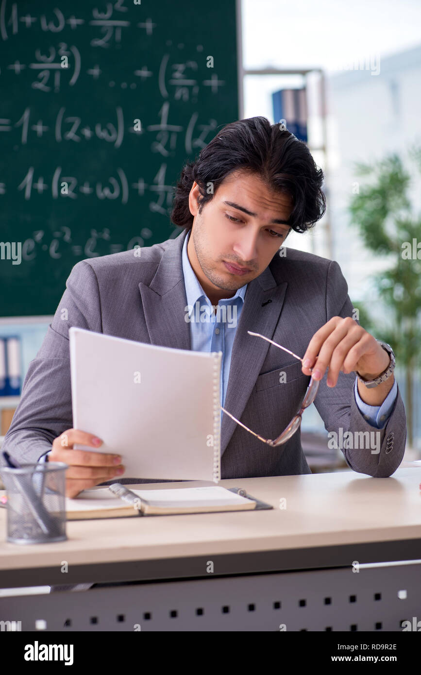 Young handsome math teacher in classroom Stock Photo