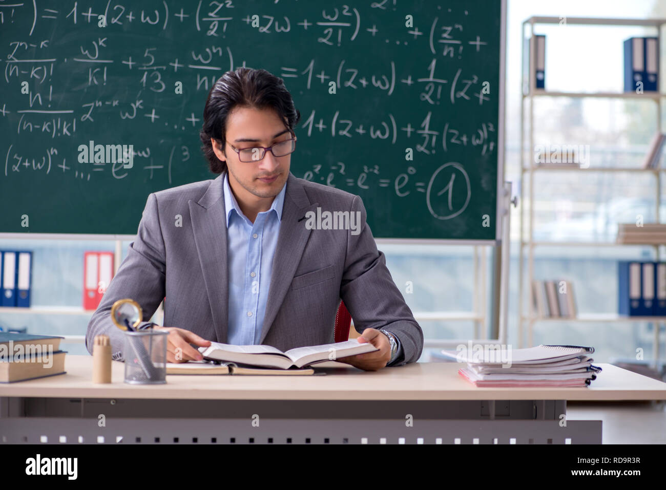 Young handsome math teacher in classroom Stock Photo